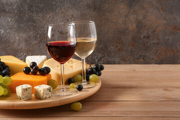 Wooden board with tasty cheese, grapes and glasses of wine on table