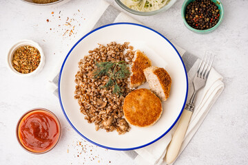 Plate of tasty meat cutlets with buckwheat and sauce on white background