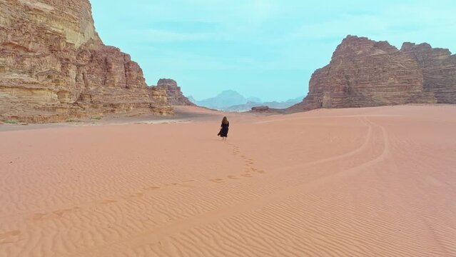 Woman Strolling On Arid Desert Of Wadi Rum In Aqaba, Jordan. wide drone shot