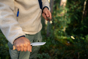 Close-up of young traveler male tourist with knife in forest