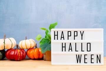 Lightbox with message HAPPY HALLOWEEN framed and pumpkins with green leaves.