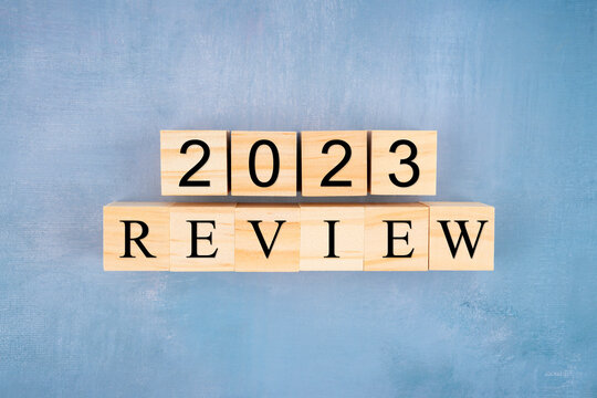 Wooden blocks 2023 with review text on wooden background.