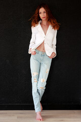 Jolie jeune femme rousse en jean et chemise - obrazy, fototapety, plakaty