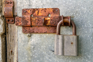 Old iron padlock. Rusty deadbolt on an old iron door.