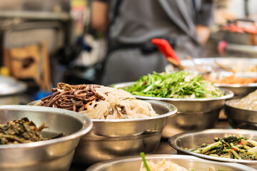 Tteokbokki, kimbap, japchae and other vegetables. Famous street food closeup at Gwangjang Market,...