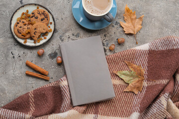 Composition with book, cookies, cup of coffee and warm plaid on grunge background