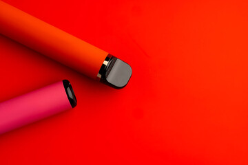 Disposable electronic cigarettes on red background close up