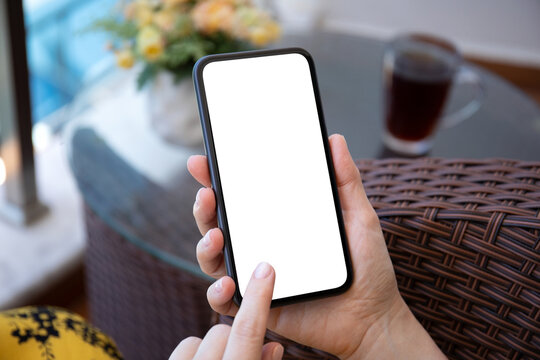 female hand hold phone with isolated screen background table house