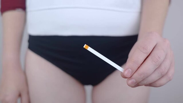 Bacterial Vaginosis. Vaginal pH. Girl shows sticks for measuring acid-base balance of genital organs. Self-diagnosis. Normal acidity level shown in colors and must be compared with the standard