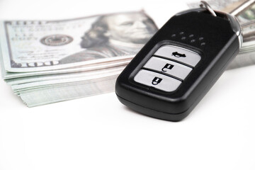 Obraz premium Black keyless remote on usd dollar banknotes with copy space below for text. Buy sell and car loan concept