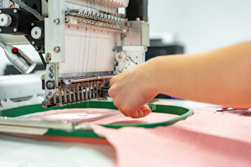 Close up of embroidery machine making patterns on textiles