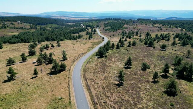 Drone flying above winding road during sunlight, amazing zigzag road. countryside landscape, High quality 4k footage