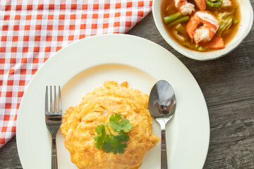 Background of fried egg over rice and tomyamkung or spicy shrimp with fresh vegetables on table in small business cafe restaurant
