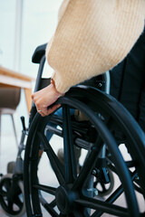 Obraz premium Hand, wheelchair and patient with a disability closeup in a home for recovery or mobility from the back. Healthcare, medical and injury with a person in a hospital or clinic for rehabilitation