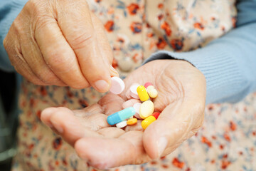 Asian elderly woman holding pill drug in hand, strong healthy medical concept.