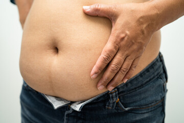 Naklejka premium Overweight Asian woman show and use hand to squeeze fat belly.