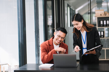 Happy businesspeople while collaborating on a new project in an office. diverse businesspeople using a laptop and tablet