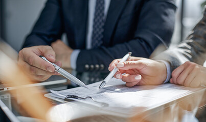 Close-up. Businessman looking at financial report and making notes with a pen in it