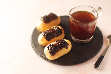 Traditional French dessert - eclairs with a cup of coffee