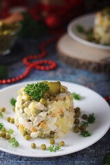 Olivier salad, traditional Russian dish, served on the plate for New Year dinner