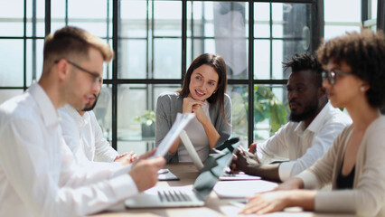 Employees working at computer together, discussing content