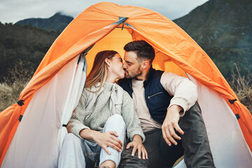 Couple, kiss and tent in camping on mountain for love, care or affection in nature together. Woman...