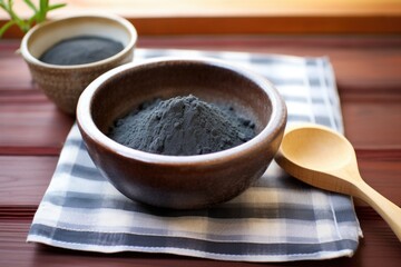 charcoal powder in a small bowl on a bamboo mat