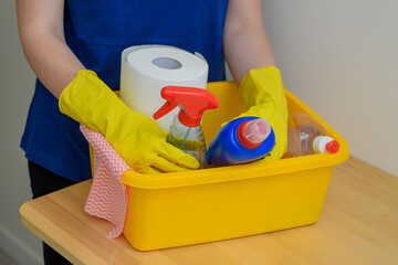 Kobieta wykonuje prace domowe, zestaw detergentów do mycia w miednicy 
