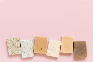 Beige and brown handmade soap bars on light pink top view. Natural herbal product for SPA