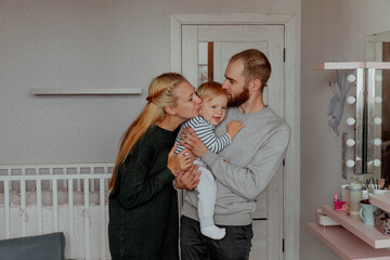 Happy family with baby, kissing and hugging kid