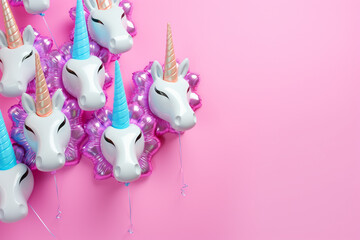 Unicorn birthday party: colorful pastel color Unicorn shape foil balloons on a pastel pink background