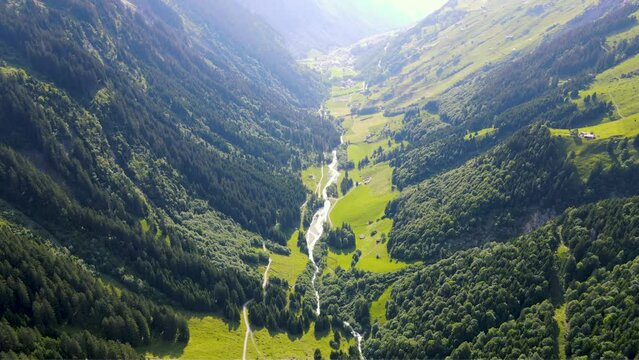 panoramic aerial view of green alpine scenery with dramatic sunlight in the Swiss Alps in Sch&auml;chental Swiss valley in Switzerland featuring Swiss river Vorder Sch&auml;chen, Untersch&auml;chen 