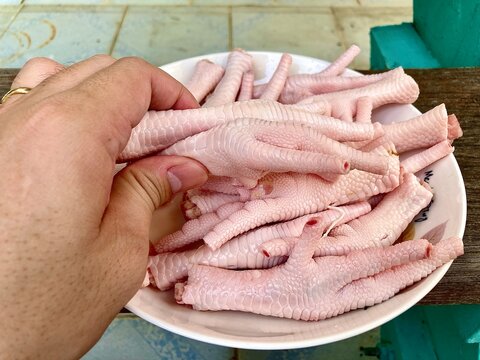 pick up chicken feet on a ceramic plate.