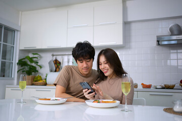 Young couple is shopping online in kitchen.