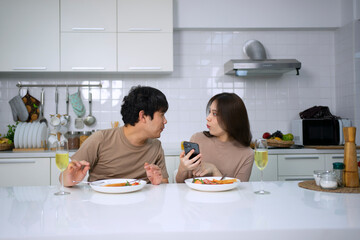 Young couple is shopping online in kitchen.