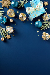 Blue and gold luxury Christmas balls ornaments, glitter blue paper gift box, fir branches on dark...