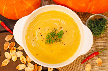 Pumpkin hot puree soup on a wooden table