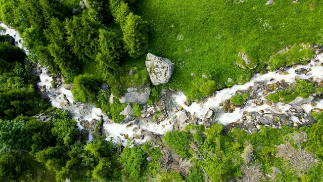 Aerial view of pristine Glacier-fed alpine river in Idyllic dark green landscape in the Swiss Alps in Switzerland featuring the Sch&auml;chental Valley and Vorder Sch&auml;chen River 
