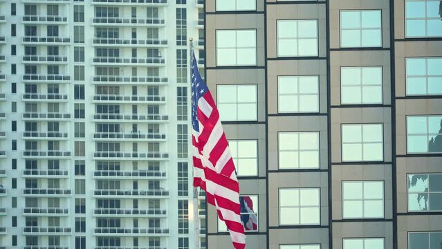 American flag waving in front of Miami skyline. Aerial view of USA stars and stripes spangled banner as symbol of democracy