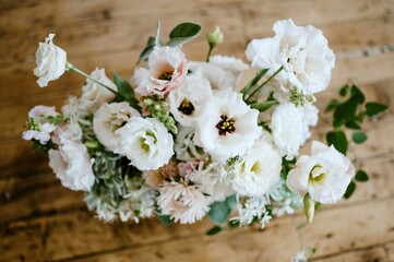 Vibrant arrangement of white flowers in a clear glass vase set atop a rustic wooden table
