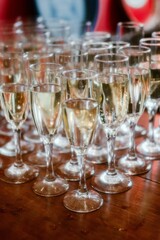 Array of sparkling crystal glasses filled with champagne atop a rustic wooden table