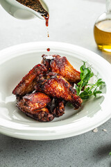 Baked chicken wings with sesame seeds and chili sauce. vertical image. top view. place for text