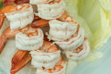 Homemade boiled shrimp appetizer served on fresh lettuce. Close up