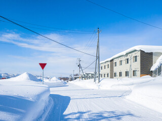 Intersection in a heavy snowfall area town on a sunny day (Niseko, Hokkaido, Japan)