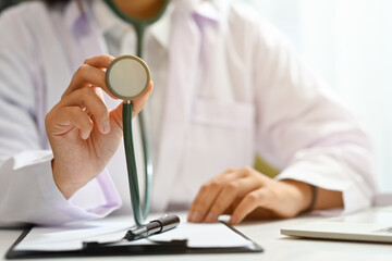 Close up doctor holding stethoscope. Cardiac medical checkup, health care and medical concept