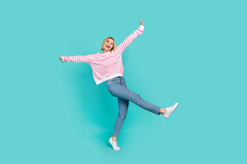Fototapeta na wymiar Full body photo of fly atmosphere youngster woman blonde bob hair hands up wear denim jeans pink jumper isolated on cyan color background