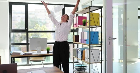 Delighted woman manager experiences euphoria and reads good news and throws papers. Happy excited young woman triumphant and receives amazing message in mail documents or correspondence