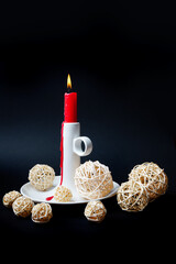 Rote Haushaltskerze mit weißem Porzellanständer und Weihnachtsdekoration