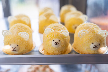 Cream cake with sheep shape in bakery refrigerator showcase at cafe. Cute hand made cake in a shape of animals. cake in the shape of sheep
