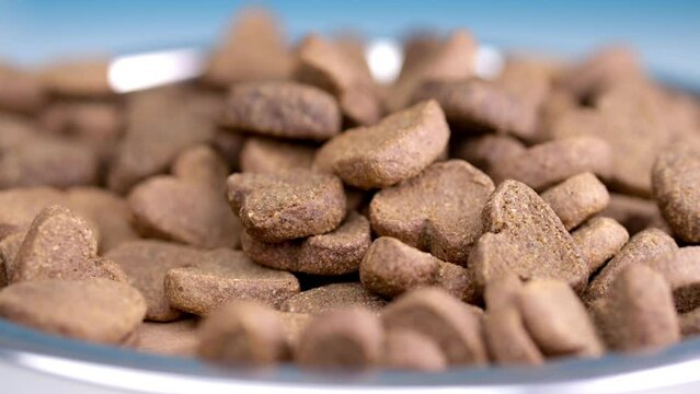 Revolving heart-emulating dog bites in a dish. Appetizing tidbits against a white setting. Showcasing owner's endearment.
